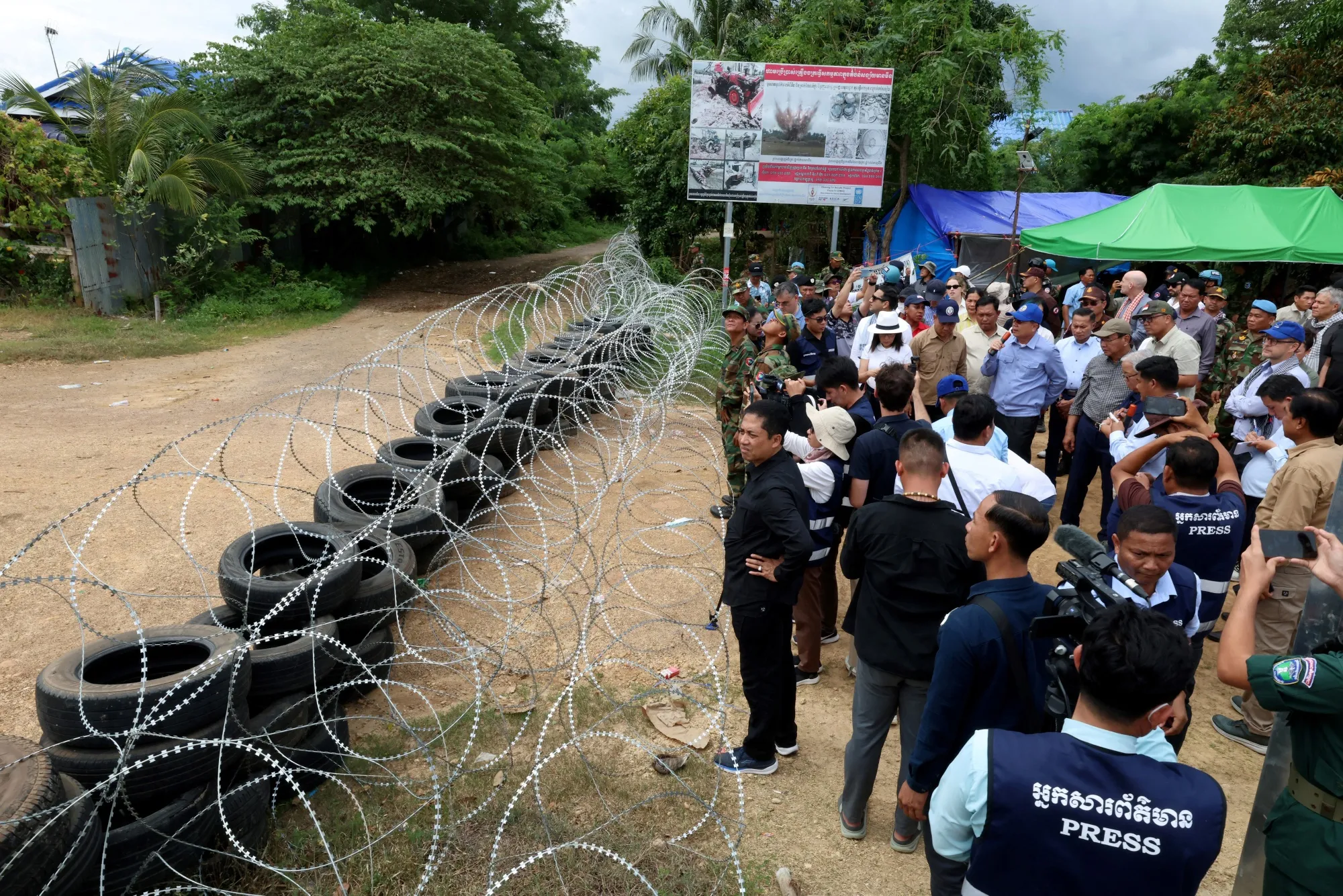 Representatives of international organizations look at barbed wire and tires that according to Cambodian officials were placed by the Thai military in a disputed area along the Cambodia-Thailand border, on Aug. 22.