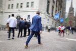Pedestrians walk along Wall Street near the New York Stock Exchange (NYSE) in New York, US, on Thursday, May 15, 2025. US stocks were on pace to snap a three-day winning streak Thursday, driven by declines in technology, energy and retailers as traders assessed a slew of mixed economic figures. Photographer: Michael Nagle/Bloomberg
