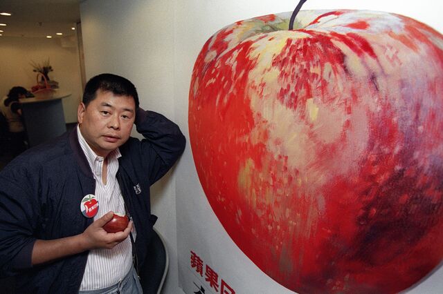 Hong Kong tycoon jimmy Lai poses in front of Apple Daily poster, June 14, 1995.