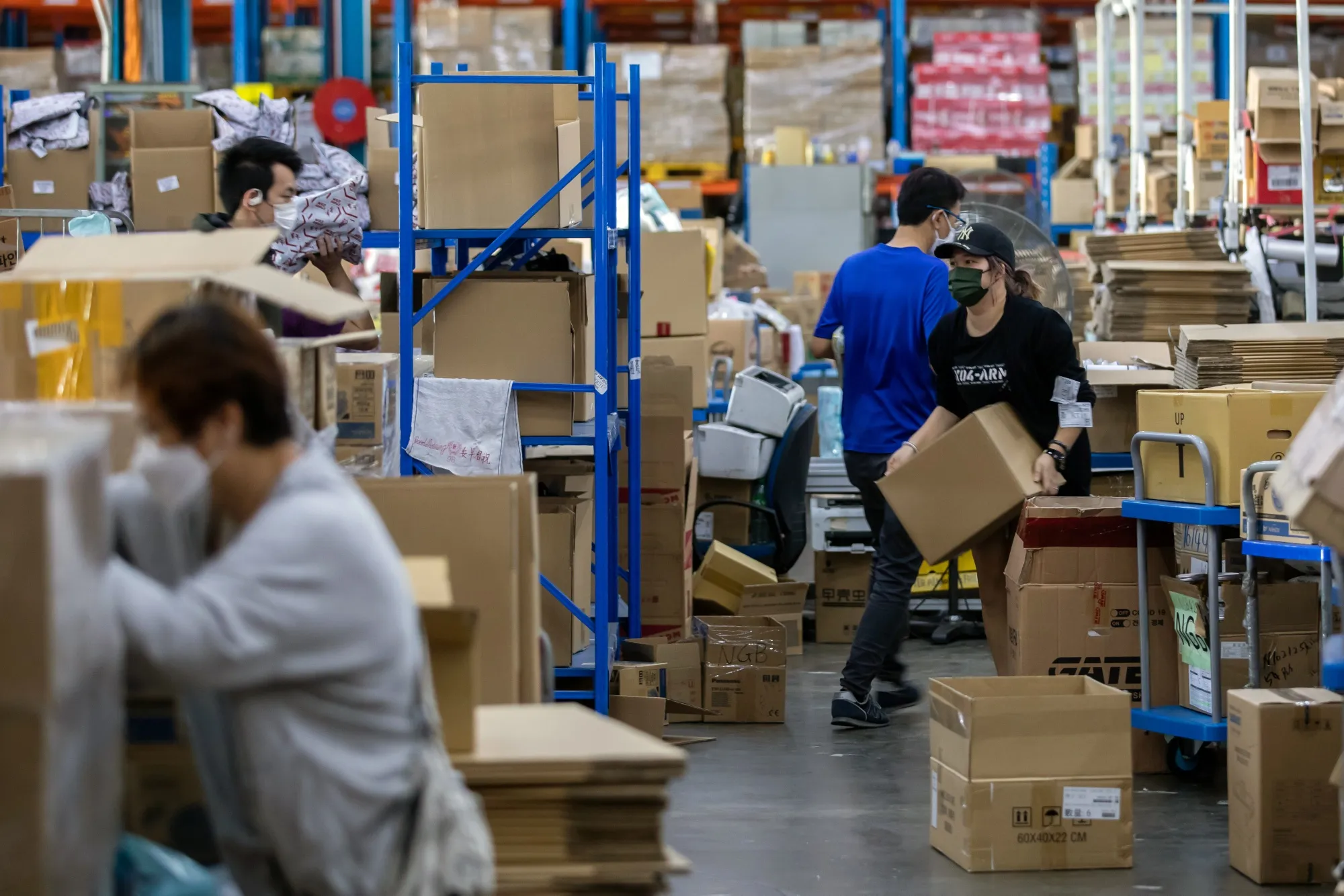 Employees pack customers’&nbsp;orders at a Ztore Hong Kong Ltd. fulfillment center in Hong Kong on Monday, March 11.