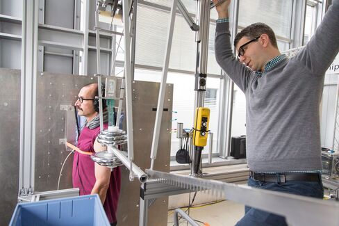 Roland Behrens, a research manager, right, prepares a mechanical pendulum for pain threshold tests at the robot collision testing facility in the Fraunhofer Institute in Magdeburg, Germany.