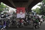Motorcyclists drive past a poster of Indonesian President Joko Widodo urging people to wear masks in Bandung, in Sept. 2020. 