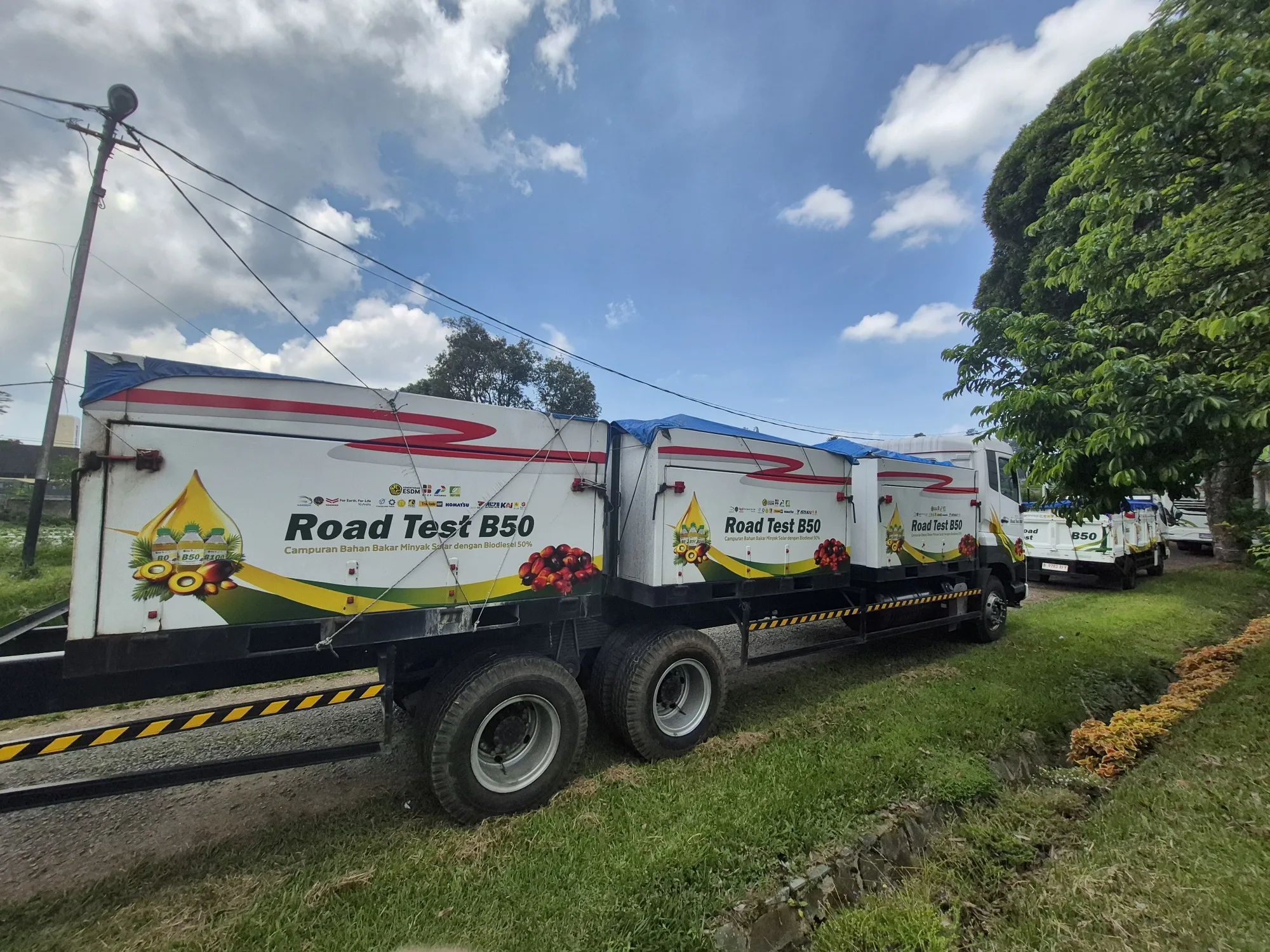 Trucks and a bus line up at a B50 blending and fuel pump station after finishing a 40,000 km road test in Lembang.