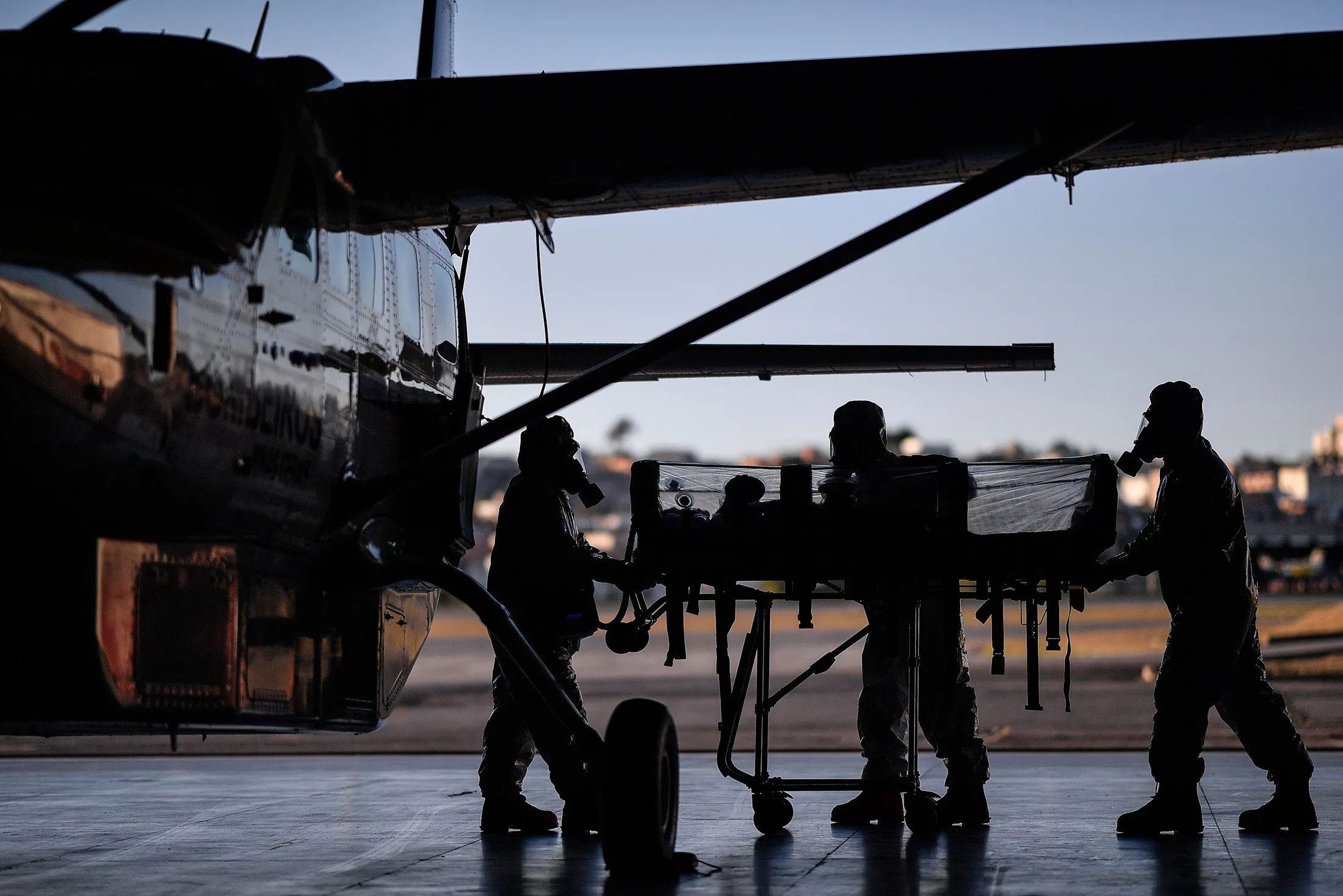 Members of the Military Firefighter Brigade of Minas Gerais (CBMMG) move an isolation stretcher used to transport remote coronavirus patients, in Belo Horizonte, state of Minas Gerais, Brazil, on July 22.