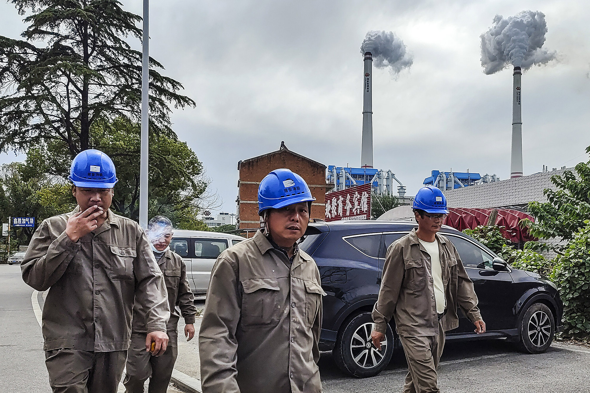 Workers walk past a coal fired power plant&nbsp;in Hanchuan, Hubei province, China.