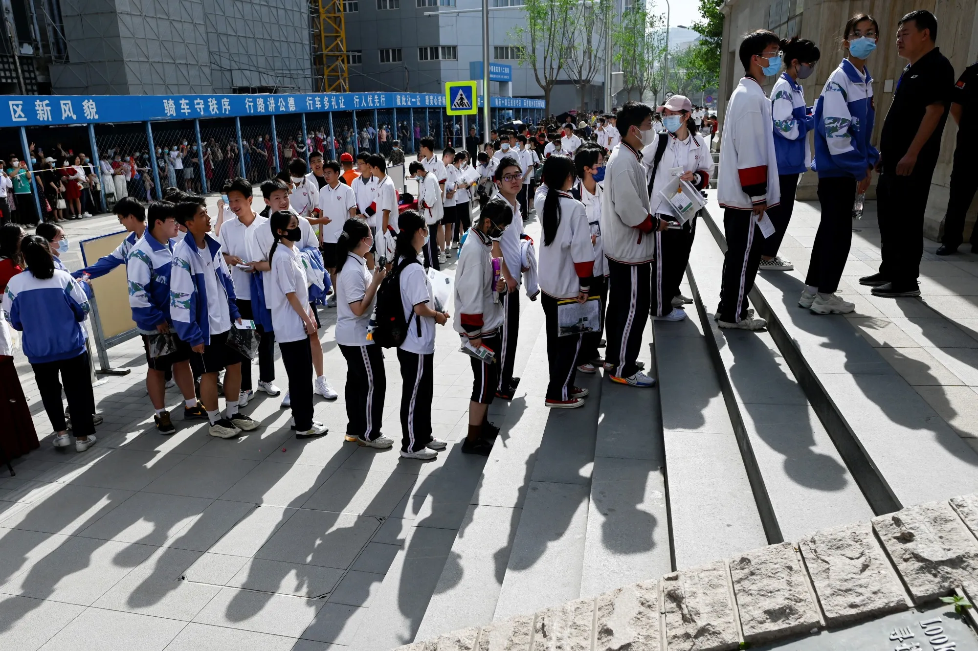 Students line up outside a school on the first day of China's national college entrance examination, known as the gaokao, in Beijing in June.