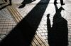 The shadows of commuters are cast on the ground in Tokyo, Japan, on Thursday, Nov. 19, 2020. Tokyo raised its Covid-19 alert to the highest of four levels, as daily infections in the Japanese capital increased by more than 500 for the first time amid a resurgence of the pathogen across the country.