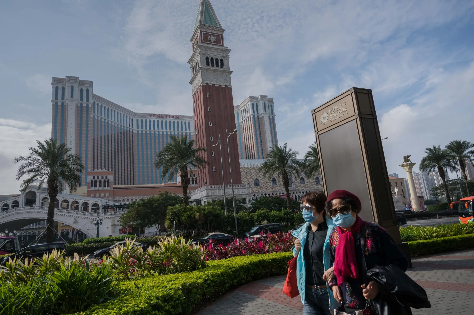 Pedestrians walk past the the Sands Cotai Central and Venetian Macao casino resorts in Macau on Jan. 24.