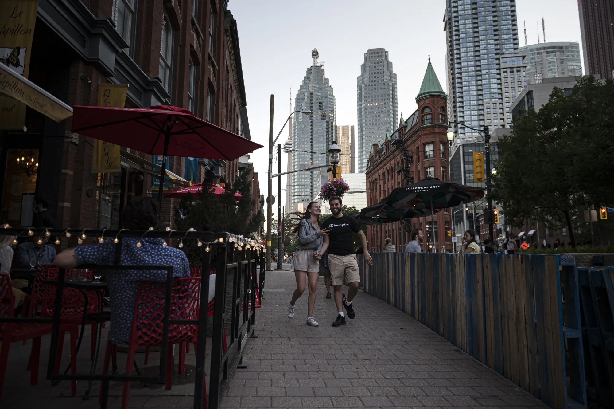 Pedestrians walk through an outdoor dining area of a downtown Toronto restaurant on June 19.