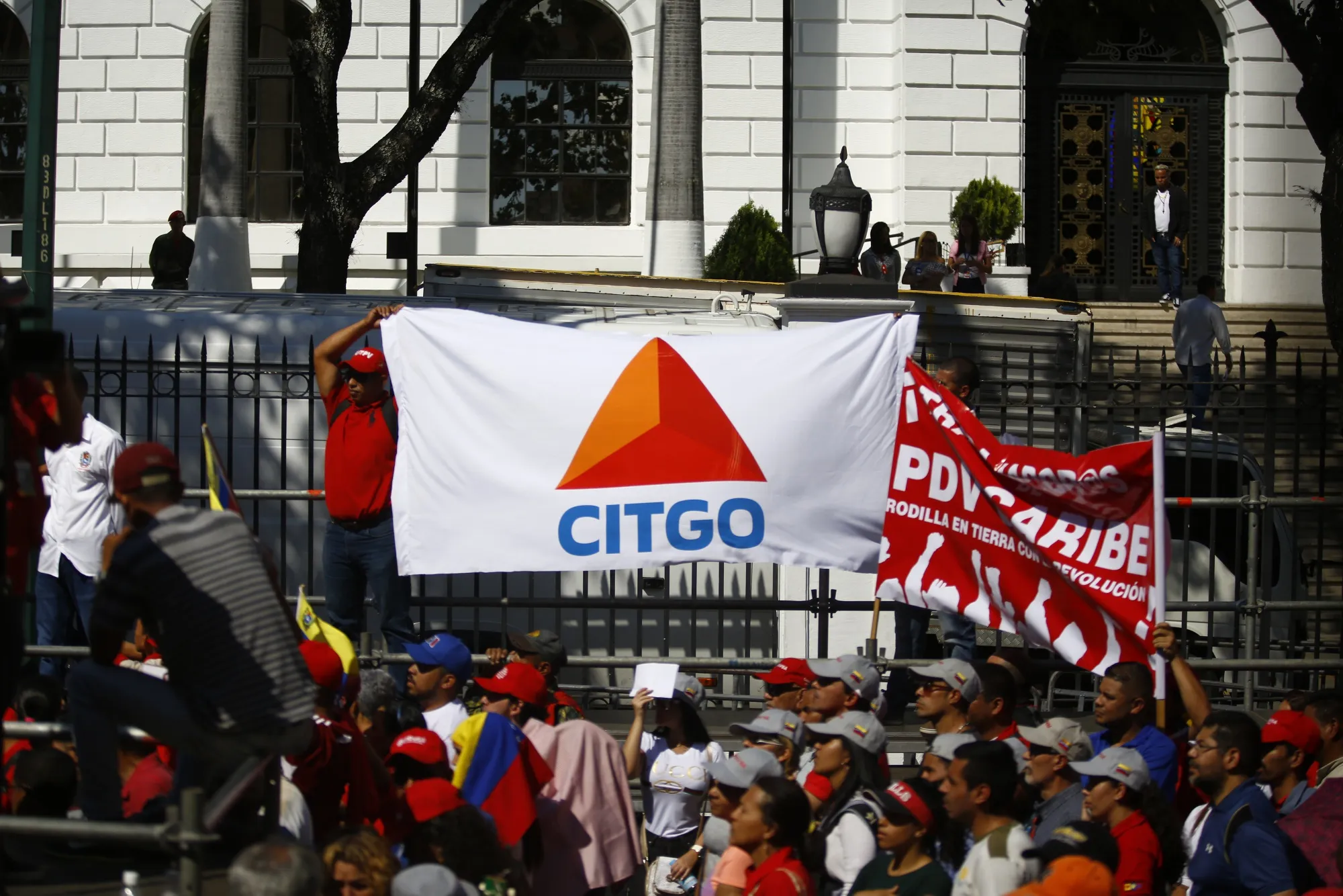 A pro-government supporter holds a banner displaying the logo of Citgo Petroleum, the U.S. refiner controlled by Petroleos de Venezuela SA (PDVSA), during a rally in Caracas, Venezuela, on Thursday, Jan. 31, 2019. The U.S. and more than a dozen other nations have recognized National Assembly President Juan Guaido as Venezuela's legitimate leader and are pressuring President Nicolas Maduro to step down, accusing him of rigging his re-election last year and leading the once-rich country into ruinous poverty.