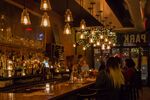 Under a tungsten sun: Brooklynites in their preferred habitat—a bar lit with Edison bulbs. 