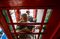 Workers fit fixtures during the installation of a Lovefone, an electronics repair shop, outlet on Greenwich High Road, in London, U.K., on Monday, Aug. 15, 2016. The U.K.'s iconic red phone booths are being adopted and re-used as businesses and nonprofits throughout the country. Photographer: Simon Dawson/Bloomberg