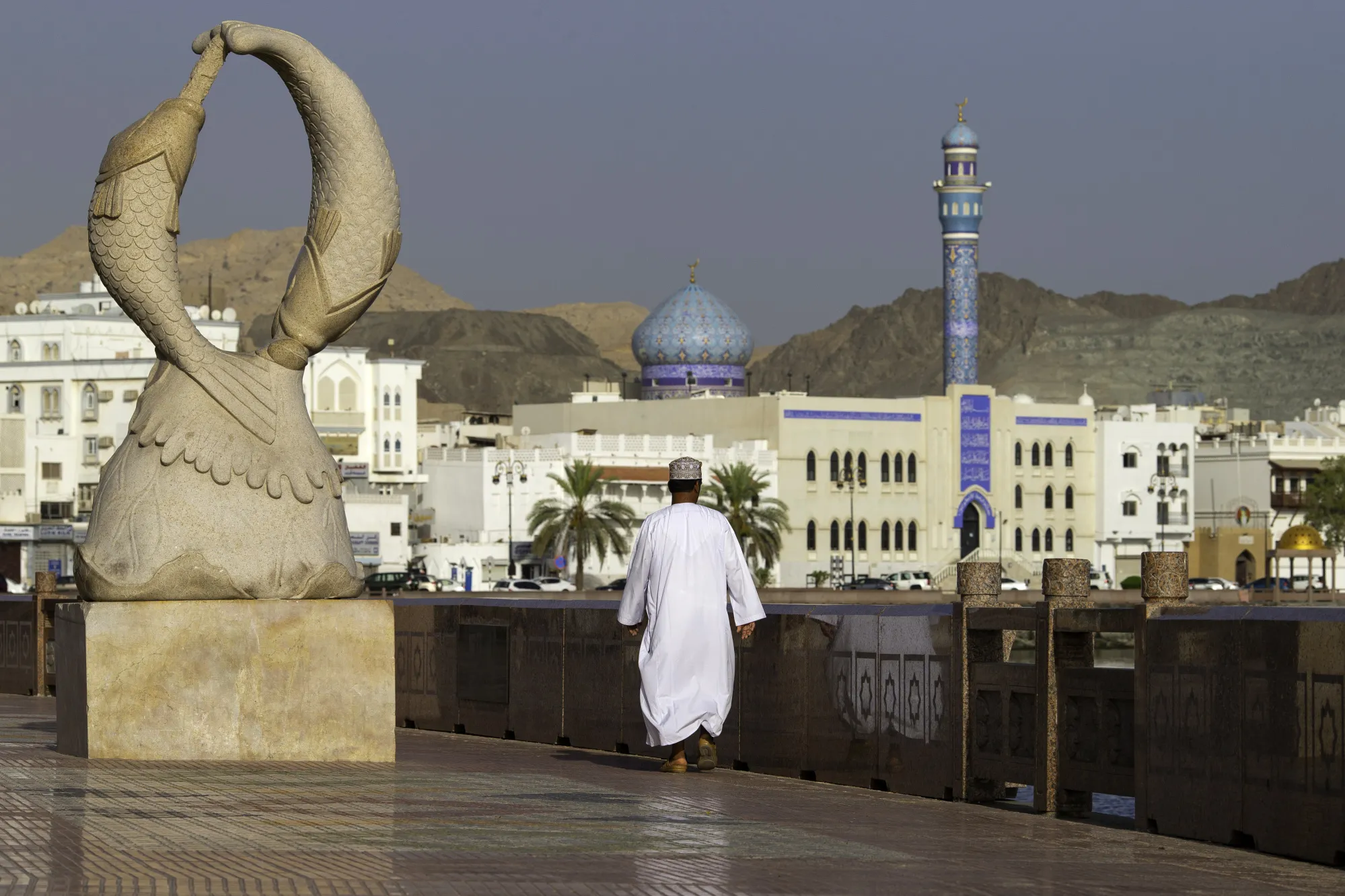 A man walks along the Mutrah Corniche seafront&nbsp;in the old city of Muscat, Oman.