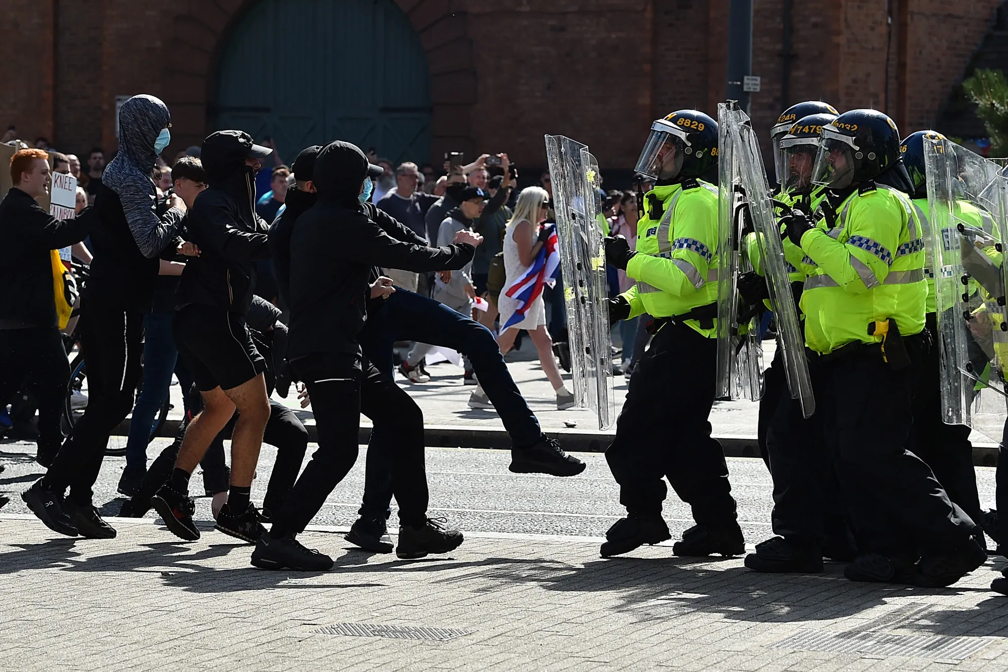 Police officers face protesters outside in Liverpool on Aug. 3.