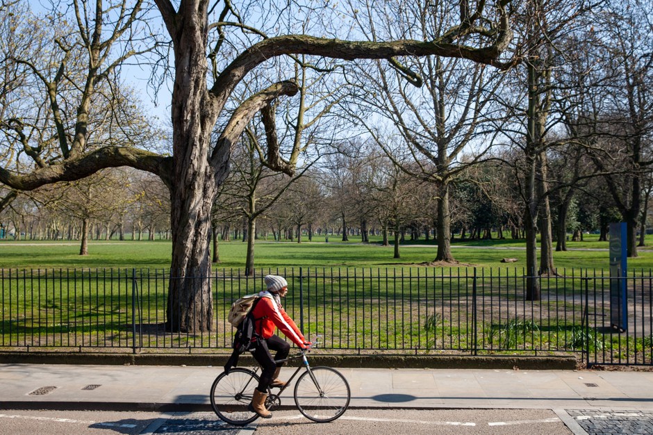 A cyclist rides past a closed Victoria Park in East London. Because of fears of crowding, several popular urban parks in the U.K. and Europe have been closed during the coronavirus crisis.