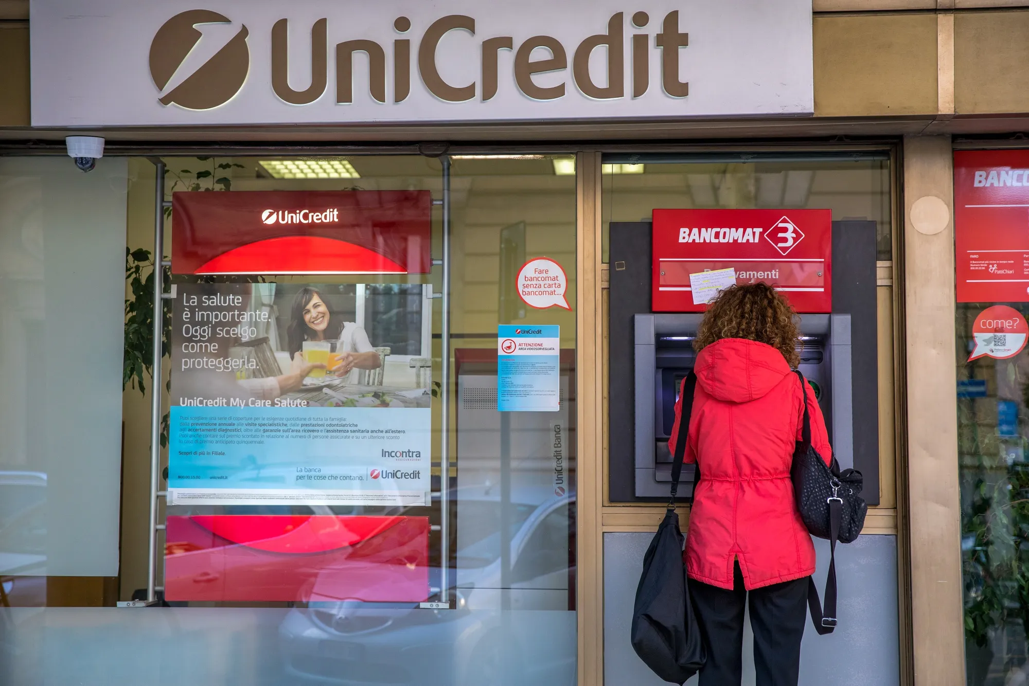 A customer uses an ATM at an UniCredit bank branch.