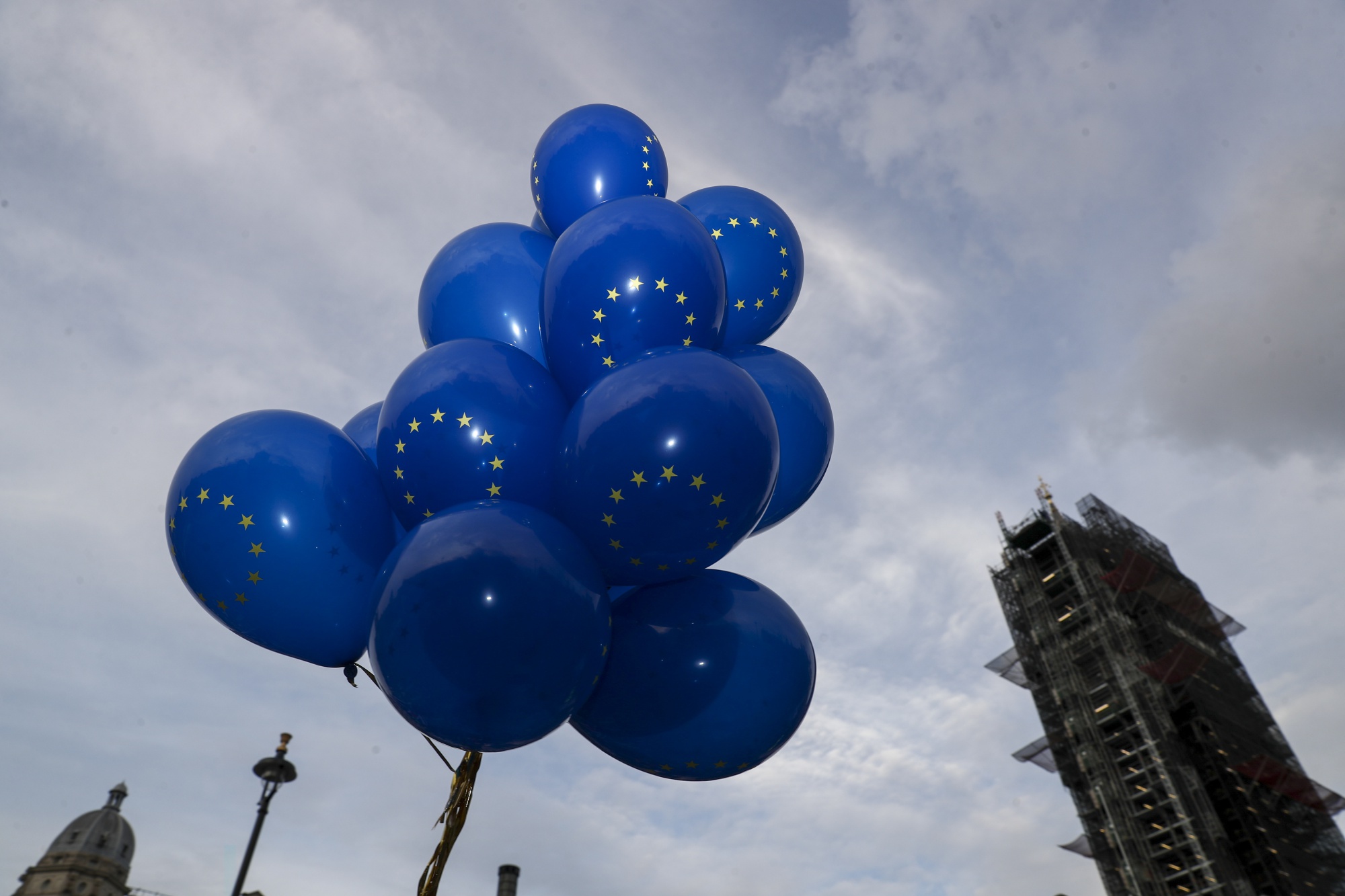 A set of balloons featuring the design of European Union (EU) flag float near the Houses of Parliament in London.