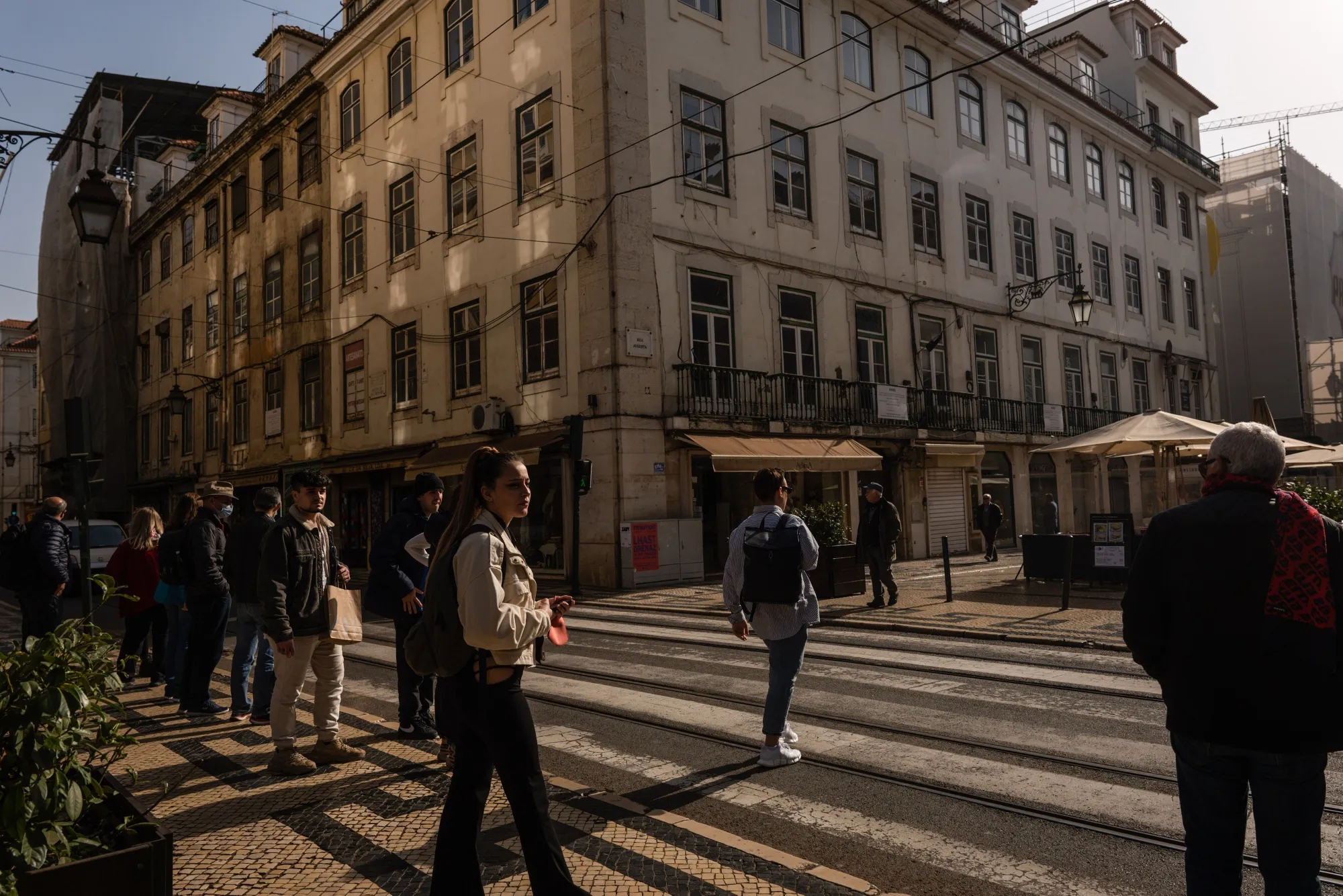 Pedestrians at a crossing on Rua Augusta in downtown Lisbon, Portugal.
