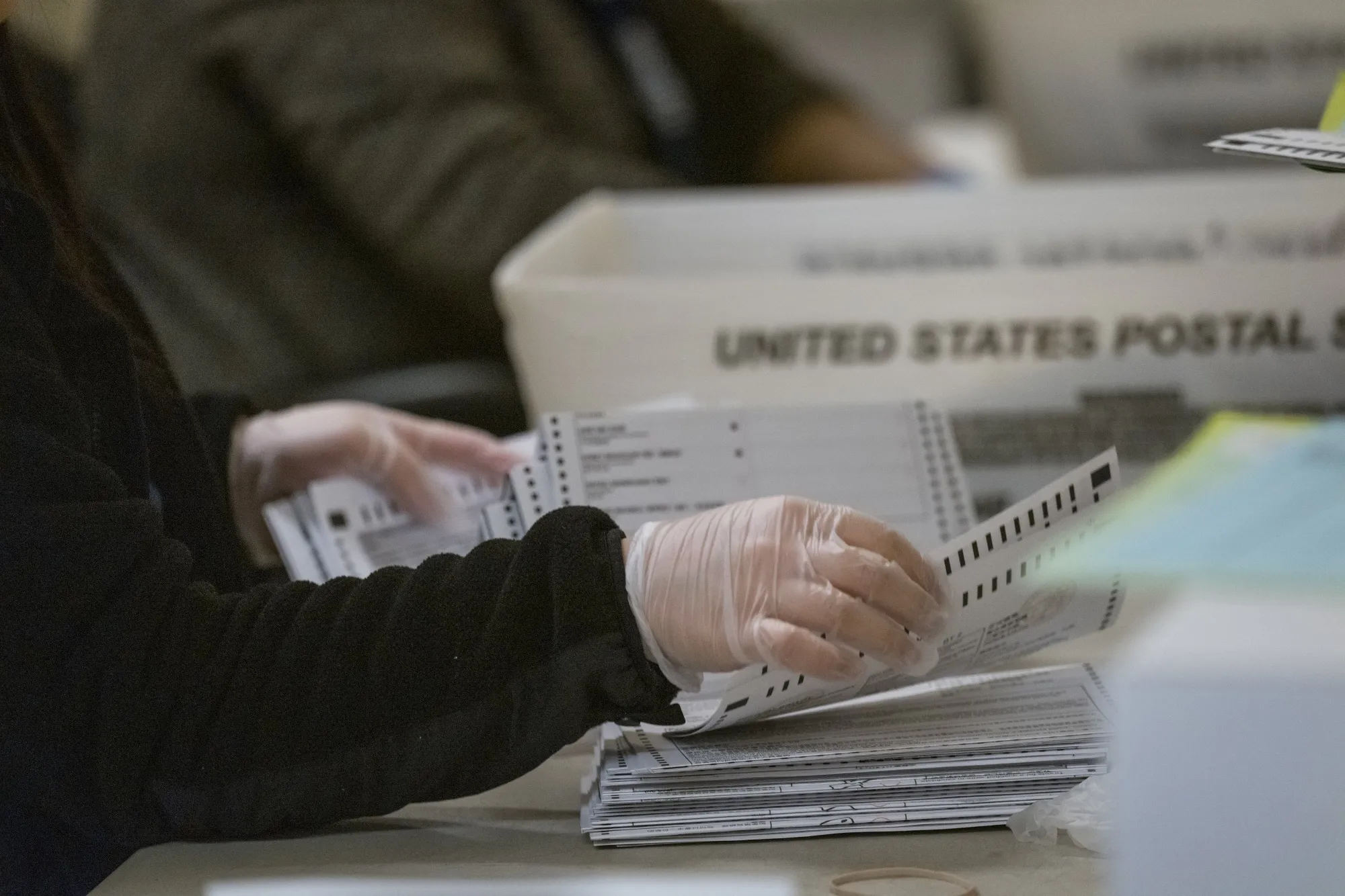 A City of San Francisco Department of Elections employee sorts through ballots at a polling station in City Hall in San Francisco on March 3, 2020.