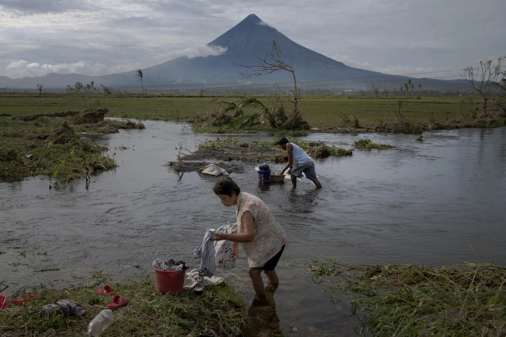 Residents wash their clothes at a body of water on Tuesday. Super Typhoon Goni, the world’s&nbsp;strongest&nbsp;storm this year, has killed&nbsp;at least 20 people and&nbsp;left thousands homeless.