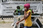 A man passes workers for the Independent Electoral and Boundaries Commission in Nairobi, during the voters registration campaign ahead of the 2022 Kenyan general election, in Nairobi, Kenya, on Feb. 4. 