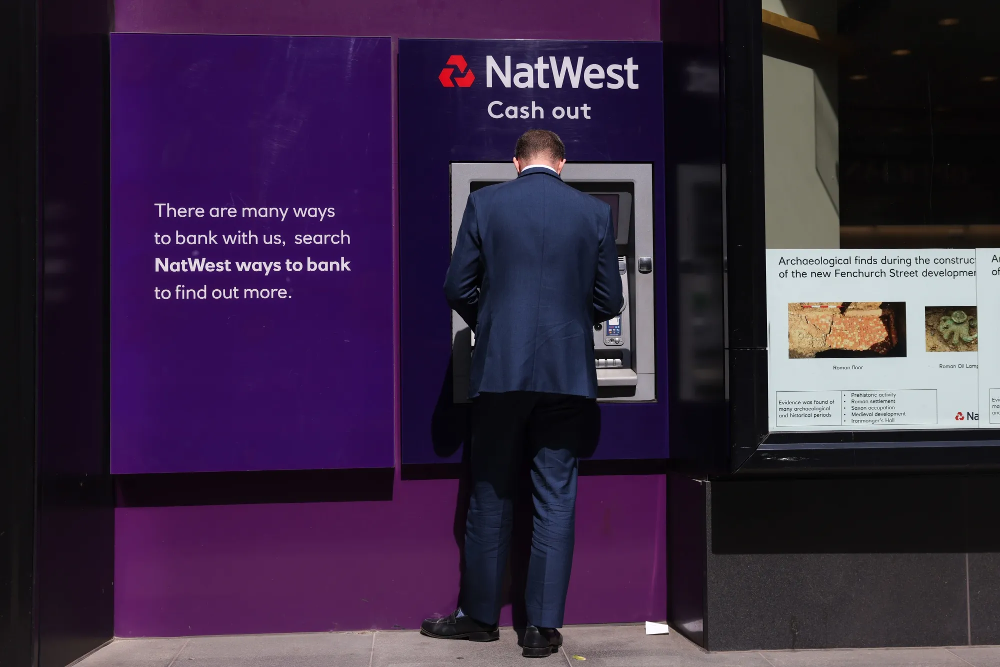 A customer uses an automated teller machine (ATM) outside a NatWest Group Plc bank branch in London, UK, on Tuesday, July 25, 2023. Natwest is due to report first-half results on Friday, July 28.