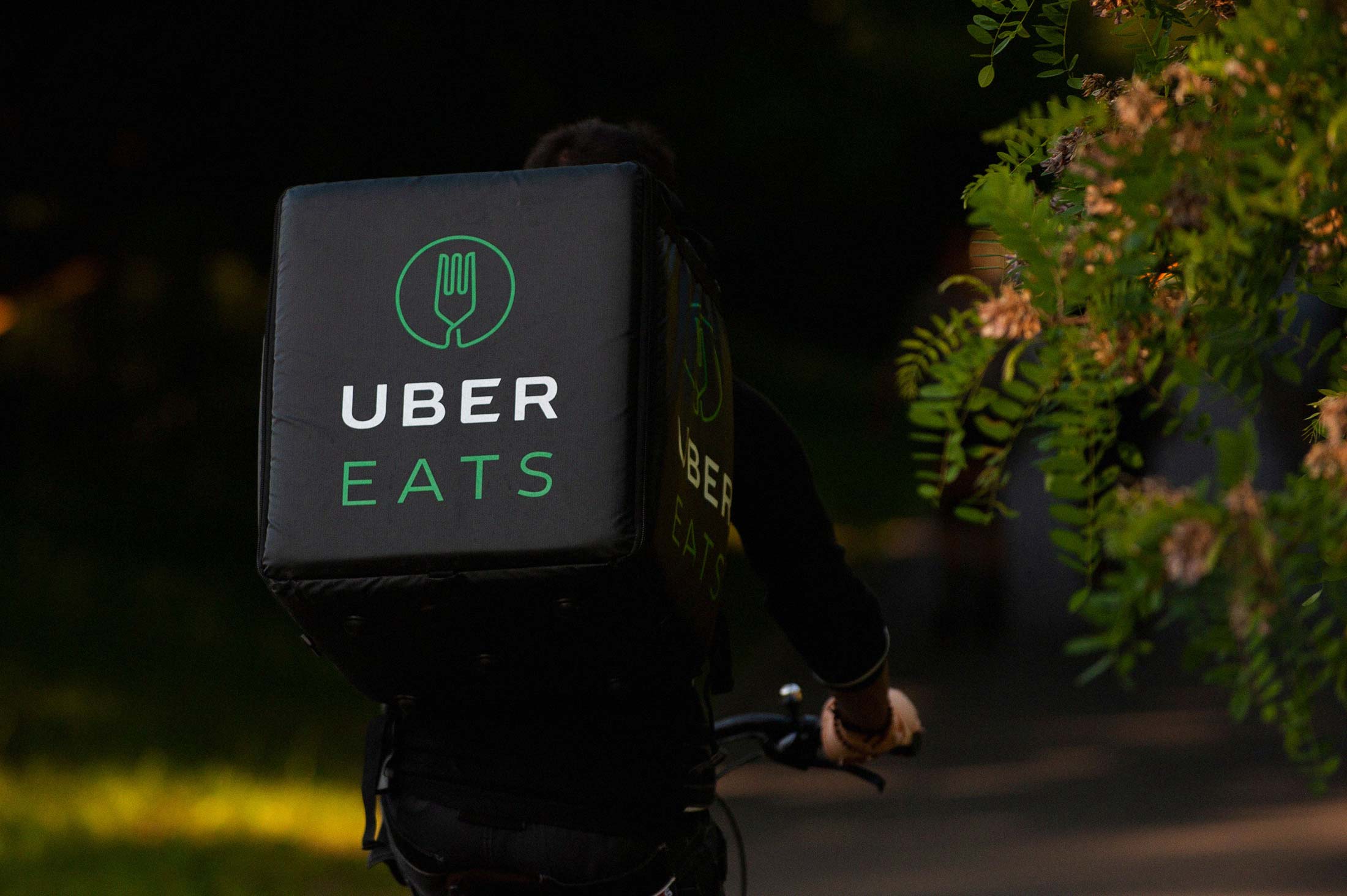 An Uber Eats rider pedals through Warsaw’s Pole Mokotowskie park.