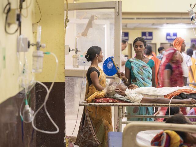 A woman fans a family member in the emergency ward at ANMMCH