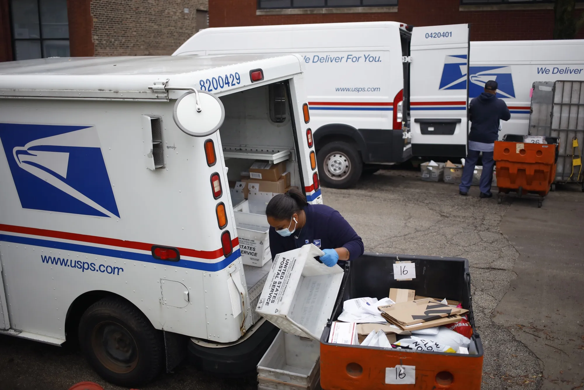 Workers load mail into delivery vehicles outside a USPS&nbsp;distribution center in Chicago, Illinois.