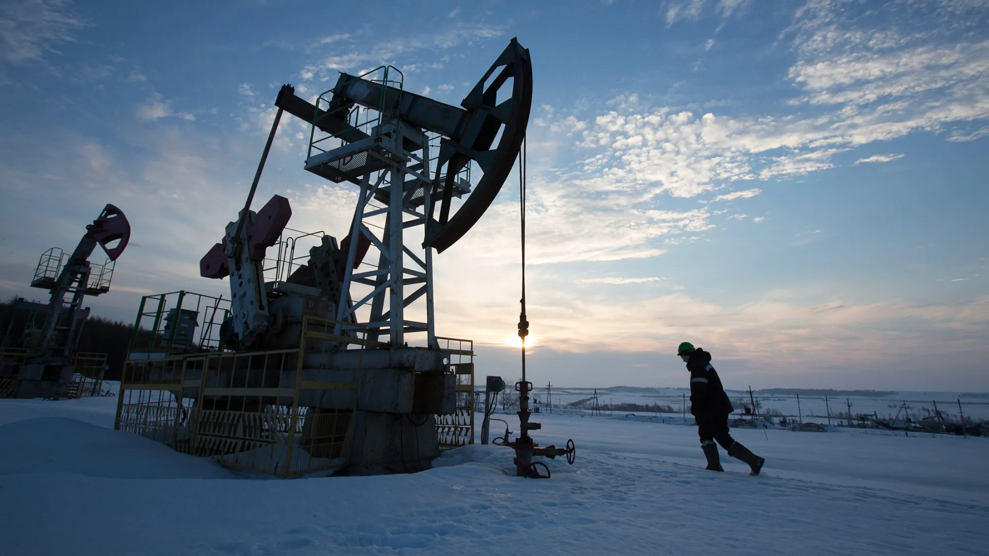 An oil worker inspects a pumping jack, also known as a 'nodding donkey,' during drilling operations in an oilfield operated by Bashneft PAO in the village of Otrada, 150kms from Ufa, Russia, on Saturday, March 5, 2016. Bashneft is an upstream and down stream oil &amp; gas provider which explores, produces and refines its own oil and gas which it extracts from brownfield reserves in the Russian Federation.
