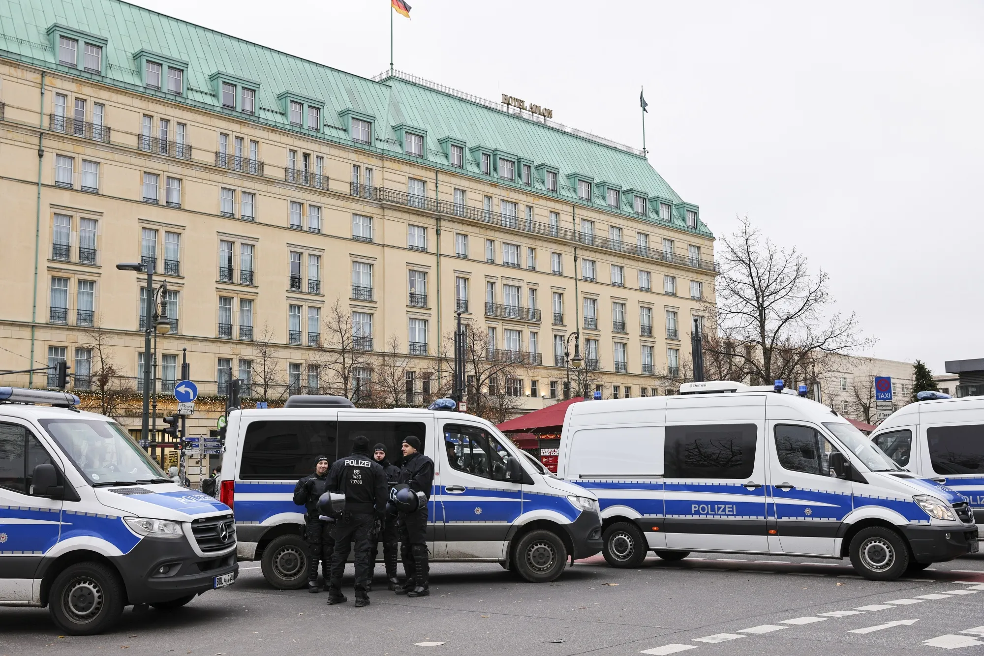 Police vehicles set a perimeter to prevent climate activists reaching the Adlon Kempinski hotel in Berlin.