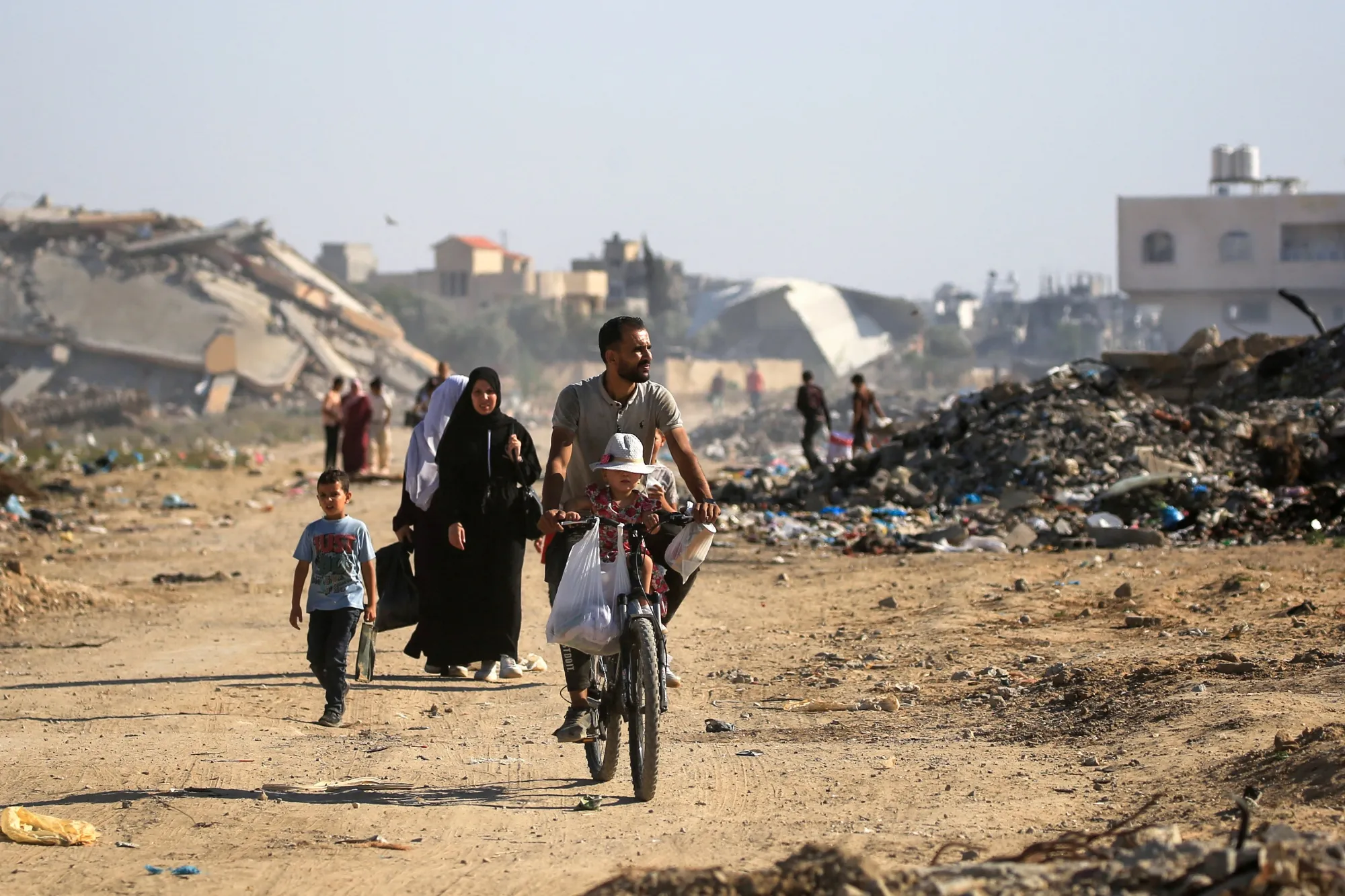 Palestinians use a path lined with destroyed buildings at the al-Bureij camp in central Gaza on June 2.