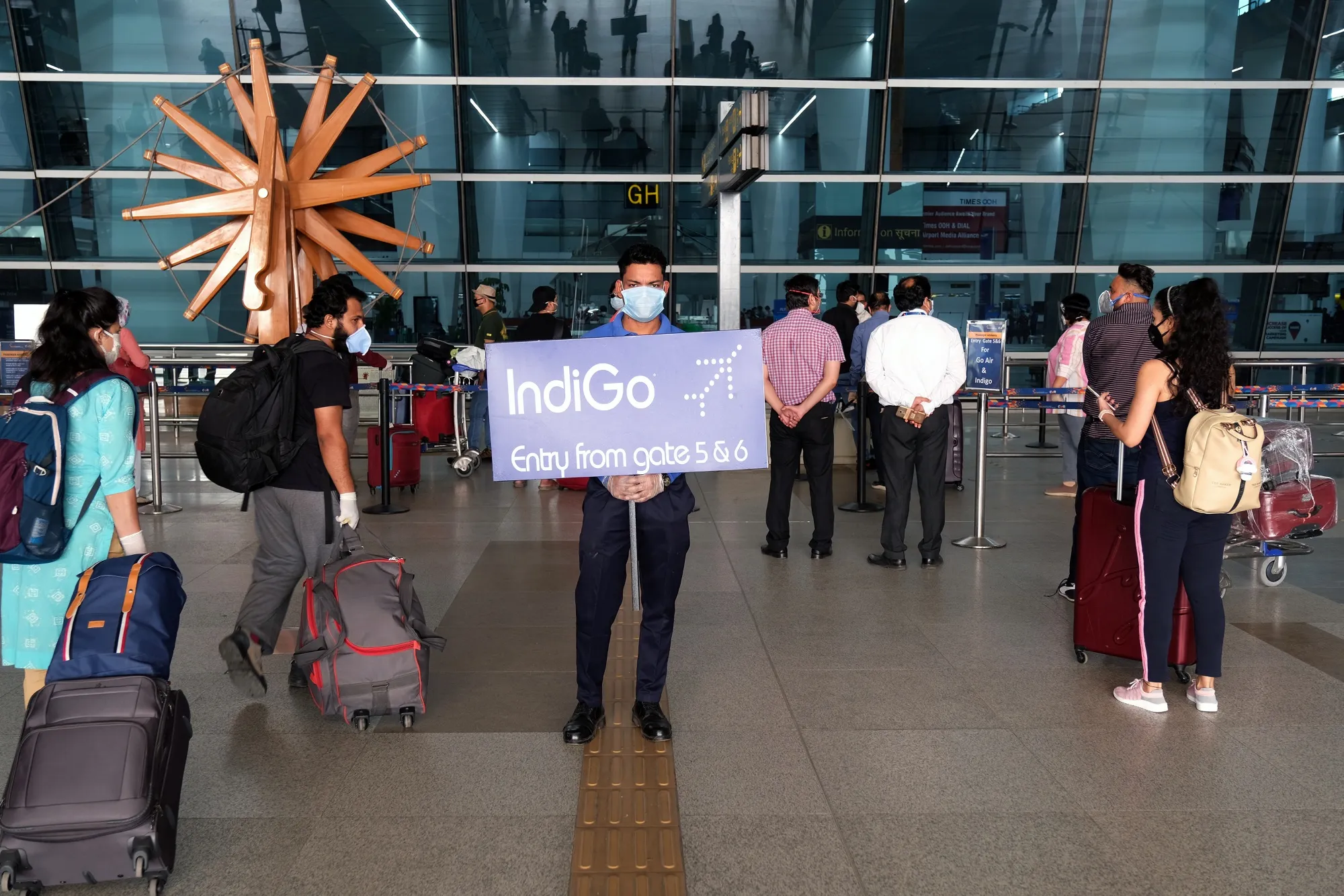 An employee displays gate information for IndiGo at Delhi Airport, on May 25.