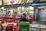 A Grab Holdings Inc. driver waits for an order outside a restaurant in Jalan Alor area in Kuala Lumpur, Malaysia, on Monday, Sept. 28, 2020. On Sunday, Malaysia saw the highest daily surge in coronavirus cases since Sept. 11, including the emergence of a new cluster in Kuala Lumpur. Photographer Ian Teh/Bloomberg
