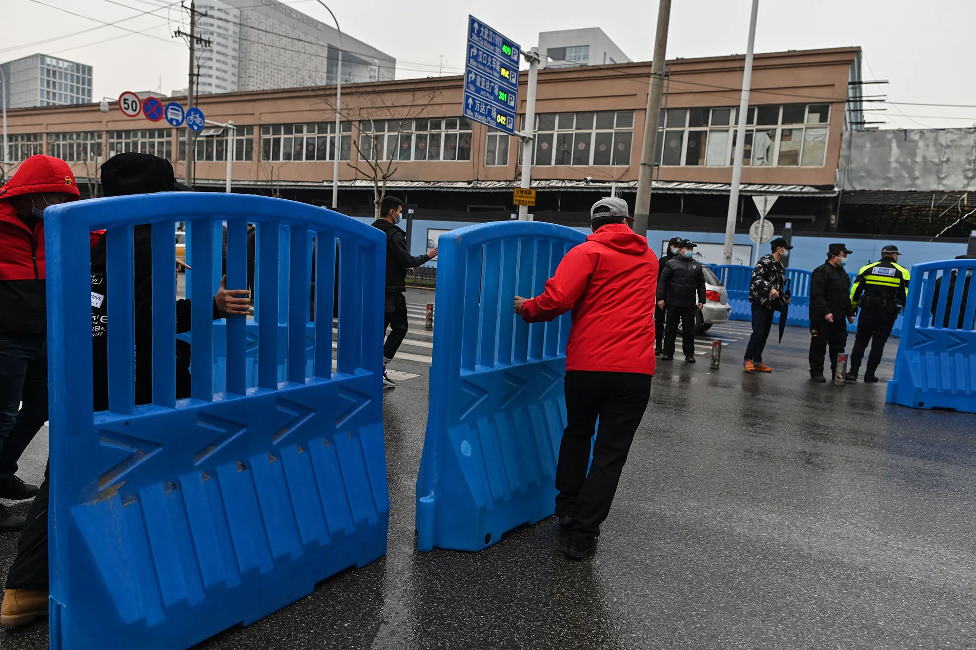 Workers place barriers outside the closed Huanan Seafood wholesale market during a visit by members of the World Health Organization&nbsp;team, investigating the origins of the Covid-19 coronavirus, in Wuhan, China on Jan.&nbsp;31.&nbsp;