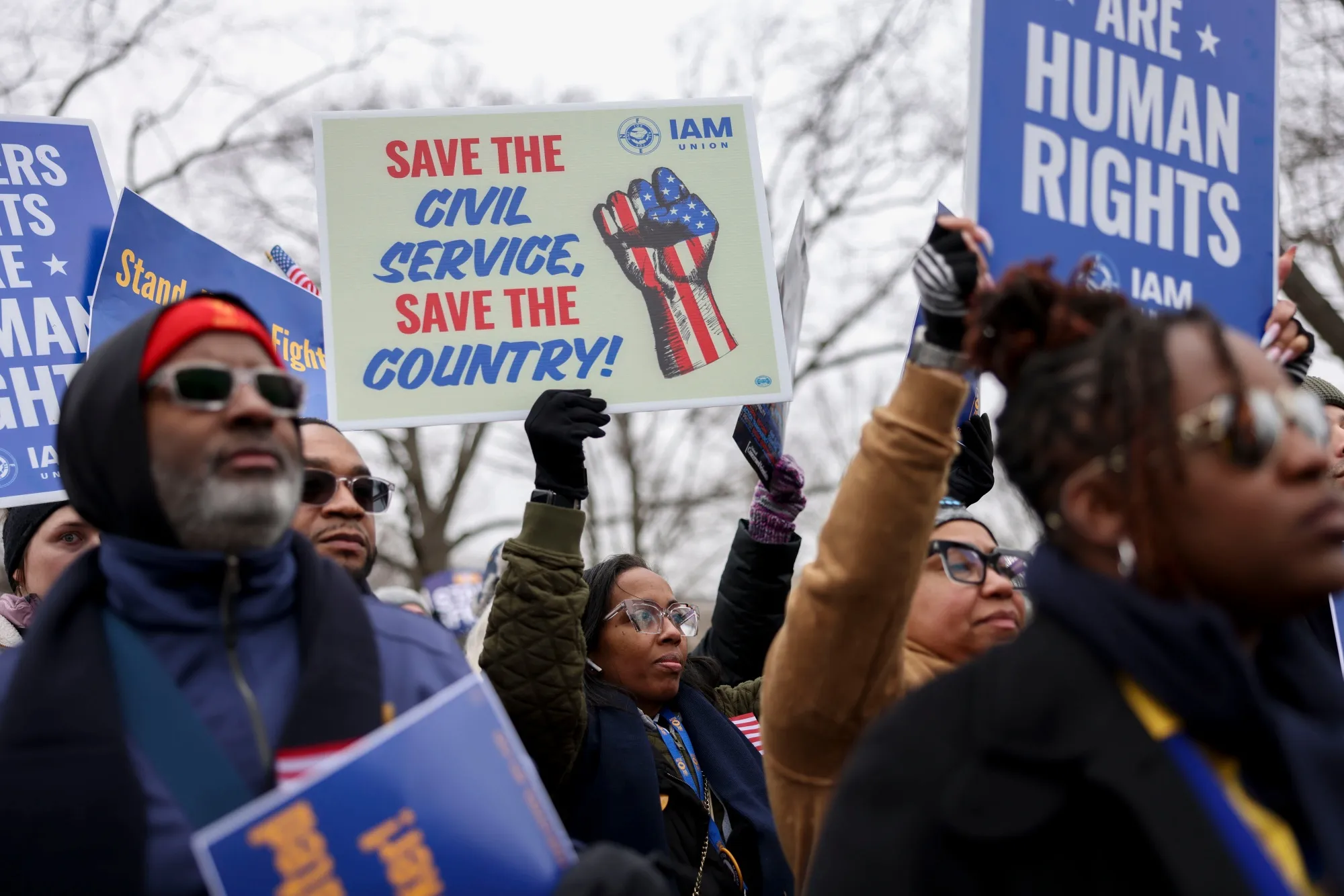 Demonstrators hold signs during a rally for federal workers at the US Capitol.