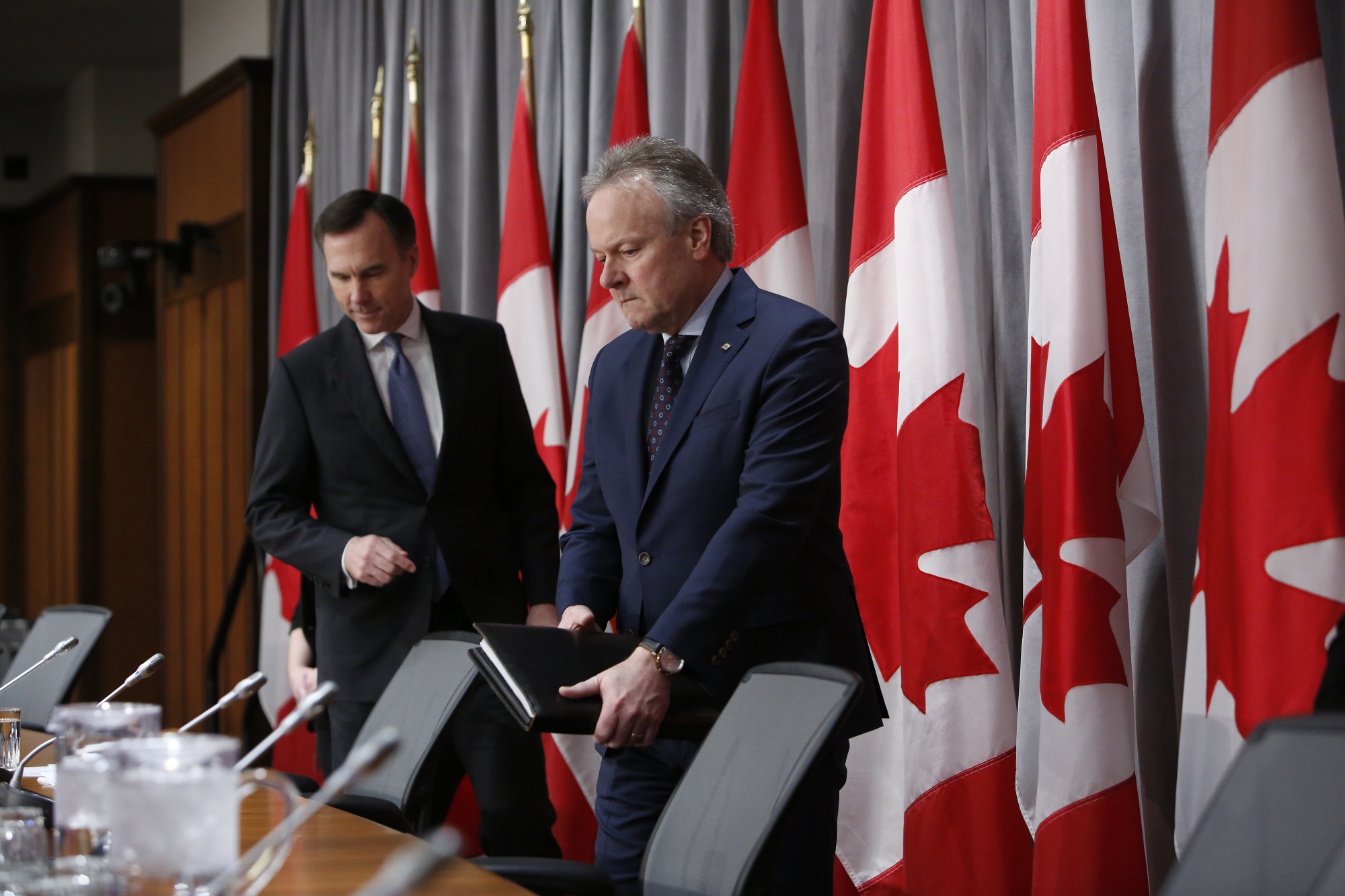 Bill Morneau and Stephen Poloz arrive at an Ottawa press conference on March 18, 2020.