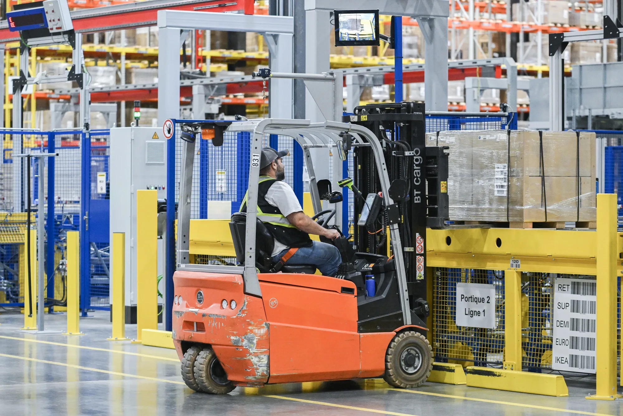 A worker loads a pallet onto an automated gantry at the Ikea distribution center in Beauharnois, Quebec, Canada