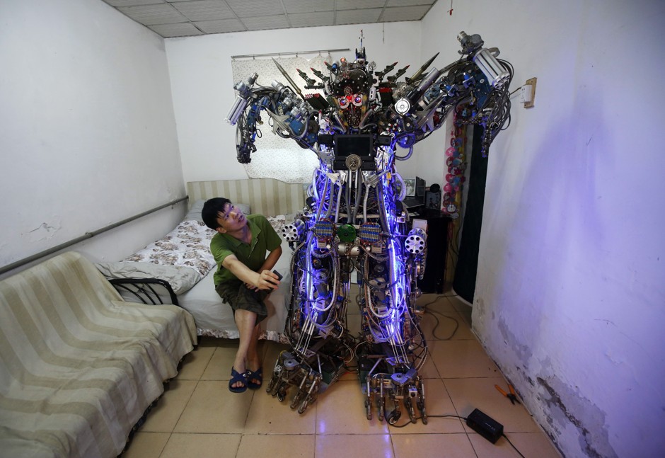 Chinese inventor Tao Xiangli controls his home-made humanoid robot with a remote controller in Beijing.