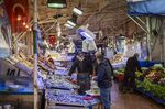 A vendor serves a customer in a local market in Bursa, Turkey,