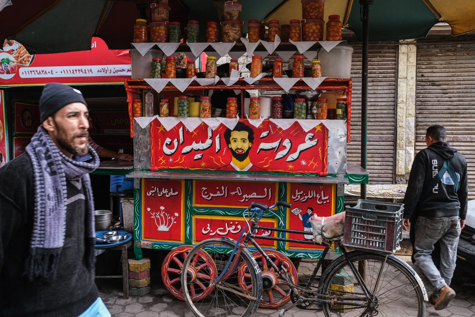 A mural of&nbsp; ball player Mohamed Salah on the side of a street vendor’s cart in Cairo, Egypt.