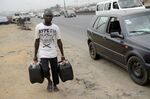 A man carries fuel in jerry cans to avoid long queues at a filling station in Lagos. Photographer: Pius Utomi Ekpei/AFP/Getty Images
