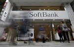 Pedestrians walk past a SoftBank Group Corp. store in Tokyo.