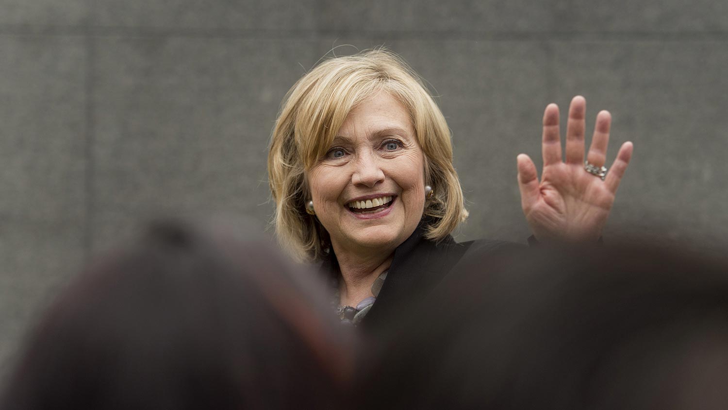 Hillary Clinton, former U.S. secretary of state, right, waves to attendees during the DreamForce Conference in San Francisco, California, U.S., on Tuesday, Oct. 14, 2014.

