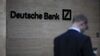 A pedestrian looks at his mobile phone near the offices of Deutsche Bank AG in London.