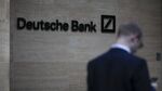 A pedestrian looks at his mobile phone near the offices of Deutsche Bank AG in London.