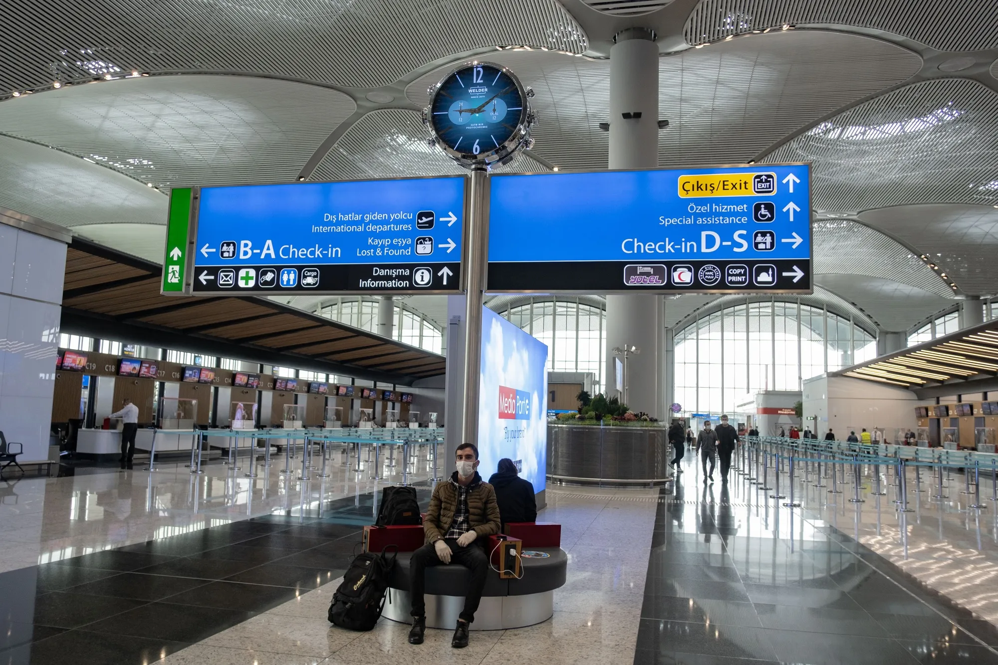 A passenger wearing a protective face mask waits for a flight at&nbsp;Istanbul Airport.