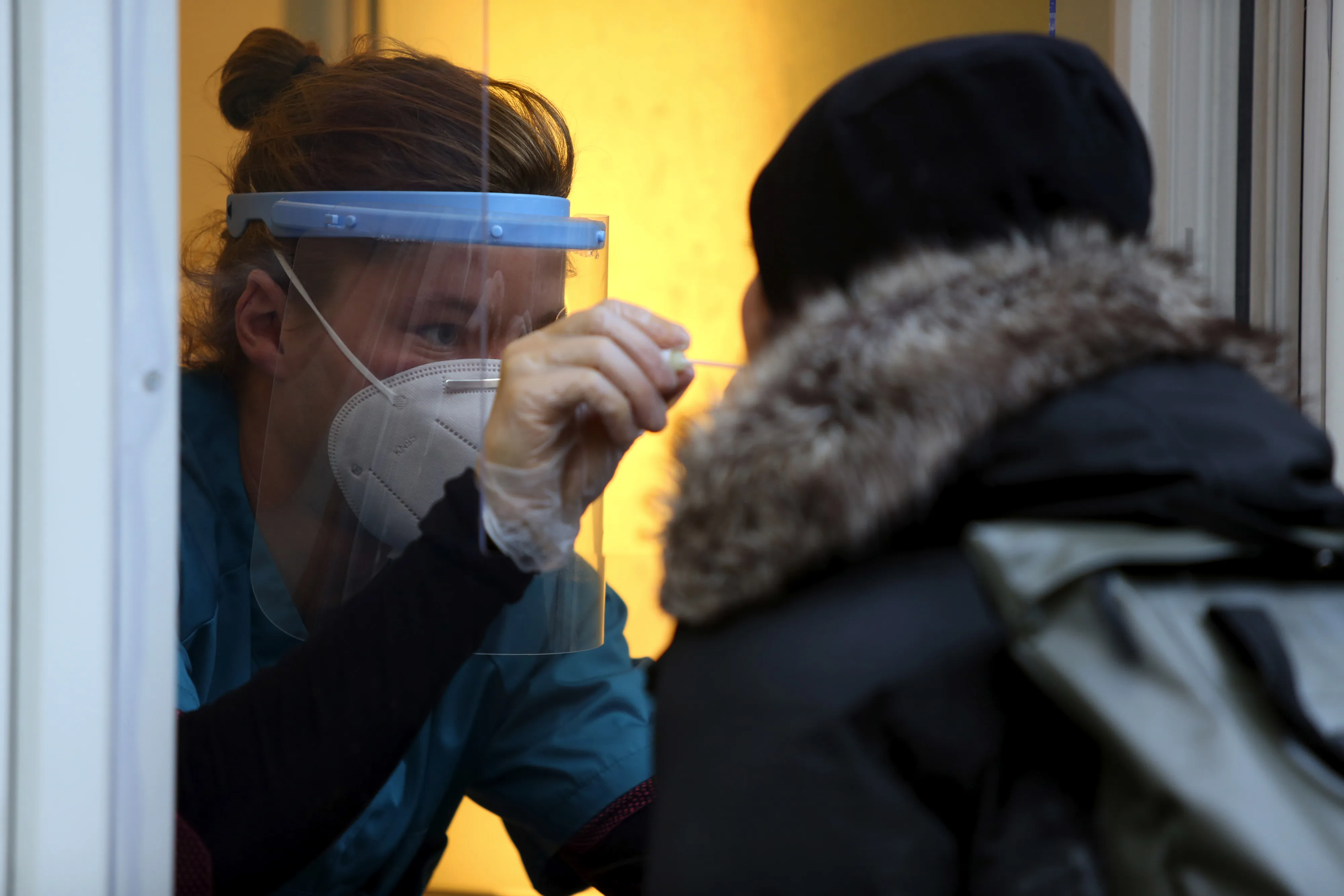 A health worker administers a Covid-19 swab test through a window of a doctors surgery in Berlin, on Oct. 12.