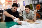 Ben Kaufman (left), founder and CEO of Quirky, and Jake Zien work on Zien’s product, an adjustable power strip called Pivot Power