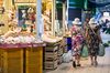 Customers carry their purchases at an indoor market in Rome, Italy.